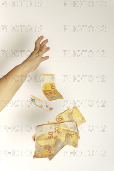 Hand throwing fifty euro banknotes in the air, depicting wealth, spending, and financial concepts
