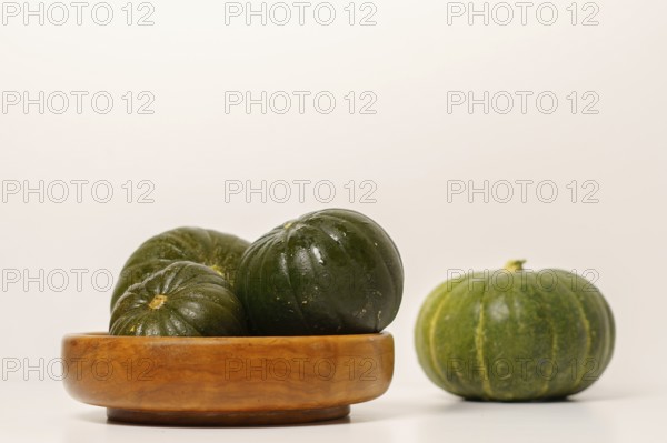 Green pumpkins cut in half on wood and white background