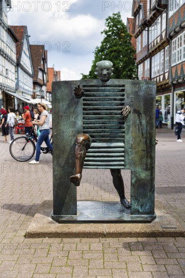 Bronze sculpture, A man pushes through the gate, French artist Joan Ipoustéguy, pedestrian precinct, footbridge, evening sky, Celle, Lüneburg Heath, Germany