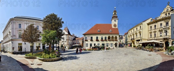 Panoramic view of a town square with historic clock tower and surrounding buildings under a clear sky Mödling Lower Austria Austria