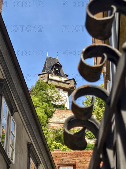 Architecturally richly decorated tower behind a forged fence with a clear sky Graz Clock Tower Graz Styria Austria