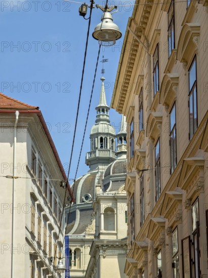 Historic buildings and a church tower under a blue sky, bustling urban atmosphere Landhaus Graz Styria Austria