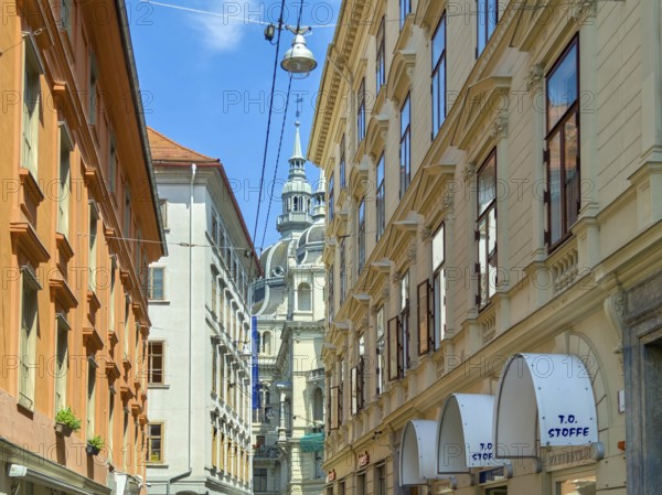 Lively old town alleyway with historic buildings and church tower in the background Landhaus Graz Styria Austria