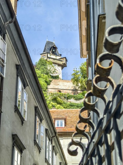 View through narrow old town street to a historic tower, flanked by old buildings Graz Clock Tower Graz Styria Austria
