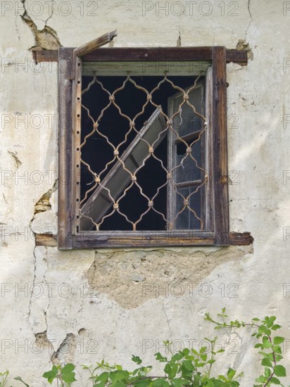Old window with wooden lattice in a crumbling wall, part of an abandoned building Styria Austria