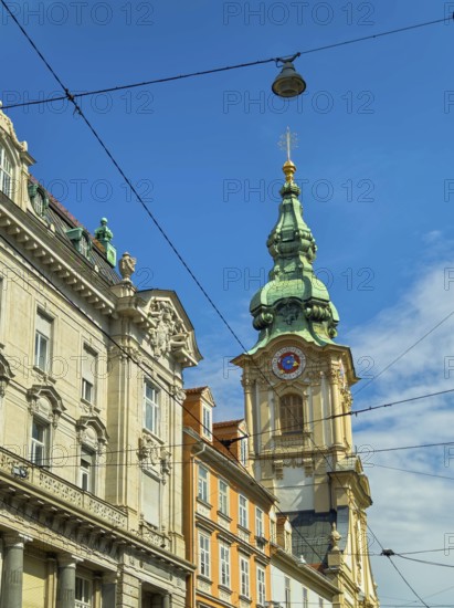 Historic building with green tower under a clear, sunny sky Herz Jesu Kirche Graz Styria Austria