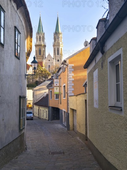Narrow old town path with a view of high church towers in the warm light of late day, Klosterneuburg Lower Austria Austria