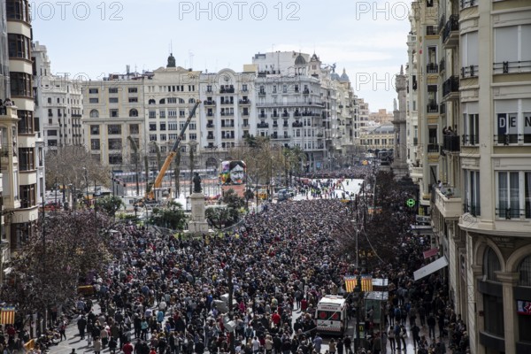 Large crowd in the city centre with tall buildings in the background MascletÃ¡ de Fallas