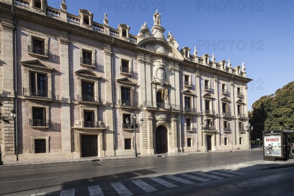 Baroque building with imposing façade on an empty street under a blue sky