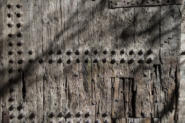 An old wooden door with visible wear and decorative nails