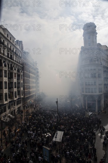 Dense crowds through a foggy city street Mascletá de Fallas