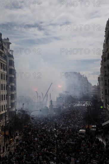 Large gathering of people in a smoky cityscape MascletÃ¡ de Fallas