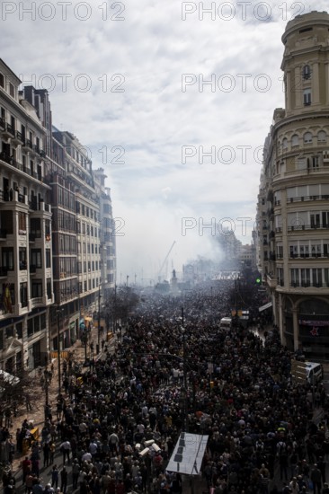 Lively street with dense crowds and billowing smoke MascletÃ¡ de Fallas
