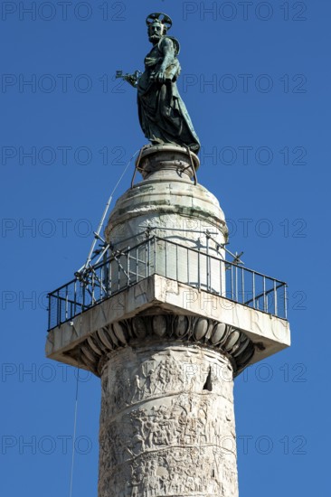 View of statue of Apostle Peter, St. Peter, Saint Peter, erected in 1587 at the behest of Pope Sixtus V, including small platform with railing and parts of spiral marble relief on column of honour Victory Column from year 113 made of Carrara marble from Lunensian marble for Roman Emperor Trajan from antiquity in Trajan's Forum in ancient Rome, Rome, Lazio, Italy