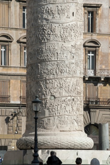 View of part of pedestal and details of spiral marble relief on column of honour Victory Column from year 113 with scenes from wars against the Dacians in Lunensian marble Carrara marble of for Roman Emperor Trajan from antiquity in Trajan's Forum in ancient Rome, Rome, Lazio, Italy