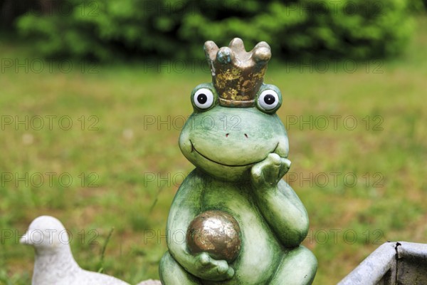Sculpture of a frog king with crown and golden ball, decoration in the garden, Schloss Holte-Stukenbrock, North Rhine-Westphalia, Germany