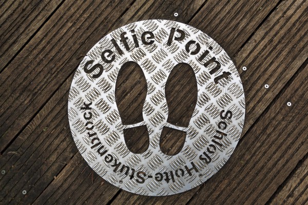 Selfie point, metal plate, shoe prints on a plank path at the source of the River Ems near Schloss Holte-Stukenbrock, Senne nature reserve, Teutoburg Forest, North Rhine-Westphalia, Germany