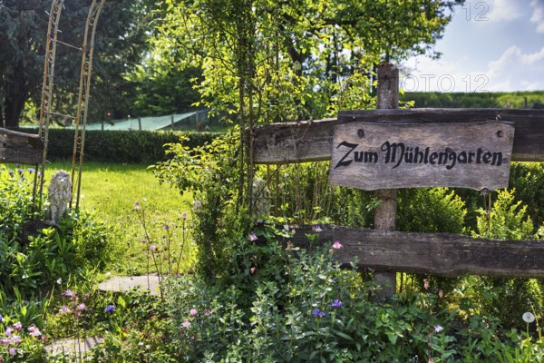 Wooden sign on the garden fence in summer, inscription, Zum Mühlengarten, country inn, historic watermill, Lügde, Weserbergland, North Rhine-Westphalia, Germany