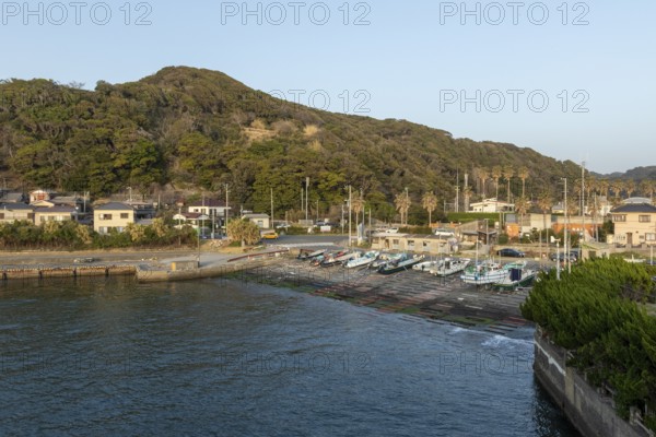 Boats in the evening light and mountain landscape in the harbour of Hamakanaya, Futtsu, Chiba Prefecture, Japan