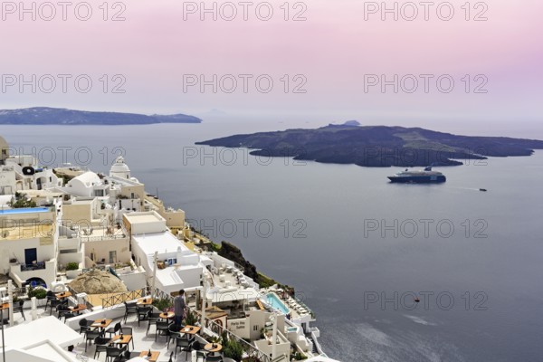 View from the island capital Fira to the uninhabited volcanic island Nea Kameni in the caldera, cruise ship, haze, Santorini, Cyclades, Greece