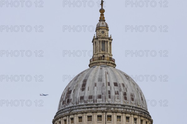 Dome of St. Pauls cathedral with a jet aircraft in the sky behind, City of London, England, United Kingdom