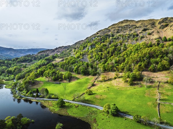Farms and Mountains over road A591 from a drone, Grasmere Lake, Grasmere, Ambleside, Lake District, Westmorland, Cumbria, UK