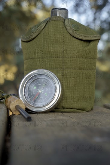 Survival kit essentials including compass, canteen, and firesteel are ready for outdoor adventure