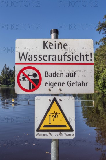 Warning sign, no water supervision, bathing at your own risk in the ArgenbÃ¼hl moor pool near Eisenharz, Baden-WÃ¼rttemberg, Germany