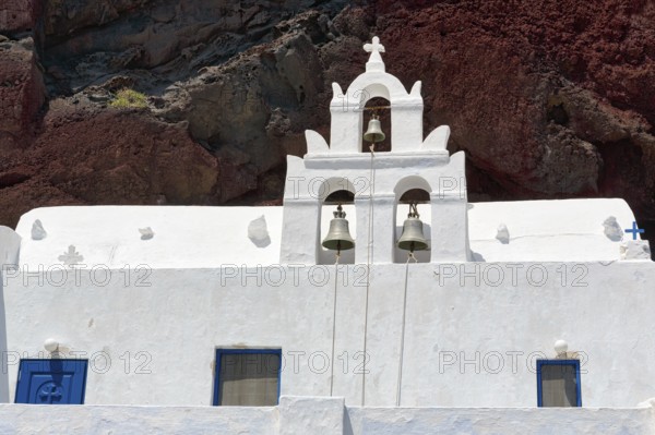 Agios Nikolaos Mavrorachidi, chapel with bell tower in front of red rock face, volcanic rock, Akrotiri, Santorini, Cyclades, Greece