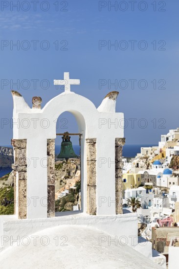 Bell tower of an orthodox church with a view of the village, Oia, Santorini, Cyclades, Greece