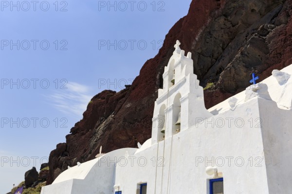 Agios Nikolaos Mavrorachidi, chapel with bell tower in front of red rock face, volcanic rock, Akrotiri, Santorini, Cyclades, Greece