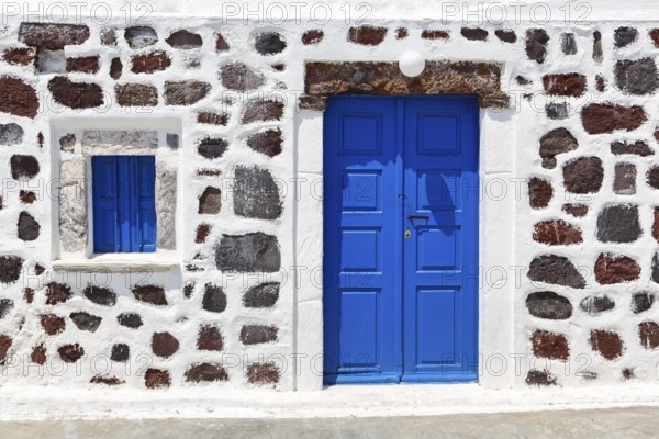 Bright blue door and blue shutter in stone wall, Chapel of Agios Nikolaos Mavrorachidi, Akrotiri, Santorini, Cyclades, Greece