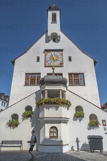 West façade with clock, floral decorations and strollers, town hall, Kempten, Allgäu, Bavaria, Germany