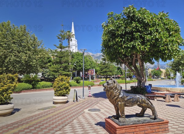 KEMER, TURKEY - JULY 5, 2025 Kemer Saat Kulesi today Cafe Mokka in the city centrum, with view from Ataturk boulevard. Beautiful Taurus mountains in the background