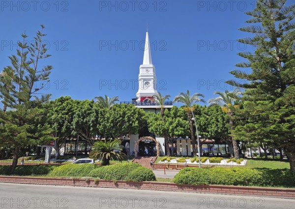 KEMER, TURKEY - JULY 5, 2025 Kemer Saat Kulesi today Cafe Mokka in the city centrum, with view from Ataturk boulevard. Beautiful Taurus mountains in the background