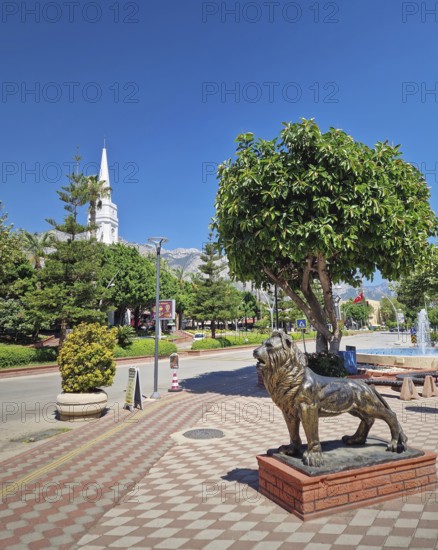 KEMER, TURKEY - JULY 5, 2025 Kemer Saat Kulesi today Cafe Mokka in the city centrum, with view from Ataturk boulevard. Beautiful Taurus mountains in the background