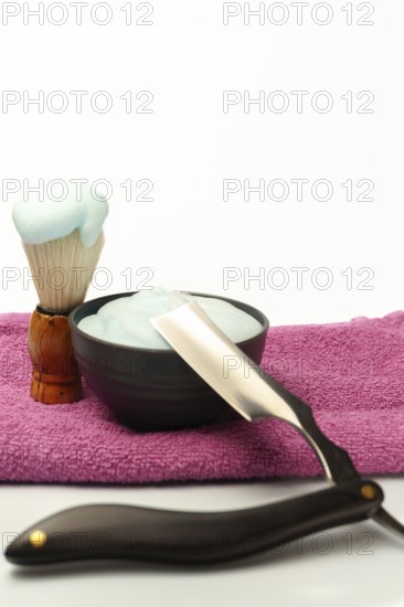 Shaving brush with foam, cream and straight razor are ready for a traditional wet shave