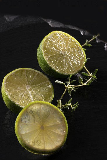 Three lime slices on a black stone plate