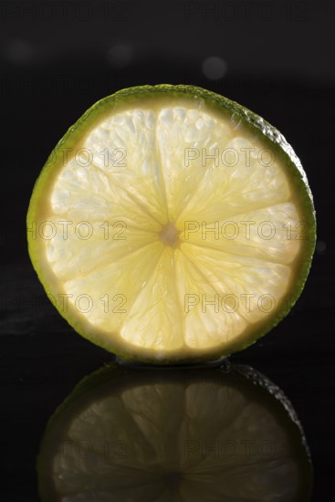 Slice of lime on stone slab with reflection