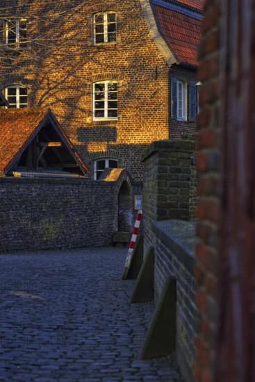 Old brick building in warm evening light with striking gable, Krefeld
