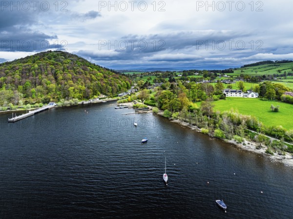 Farms and mountains over Ullswater Lake from drone, Pooley Bridge, Lake District National Park, Cumbria, England, United Kingdom
