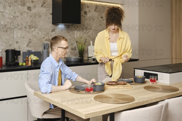 Dinner preparation and enjoyment in contemporary home kitchen on a relaxed evening