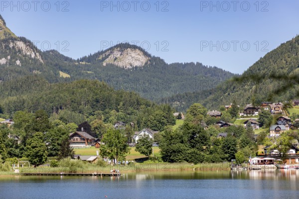 Idyllic landscape with houses by the lake, framed by wooded hills and mountains, Altaussee, Styria, Austria