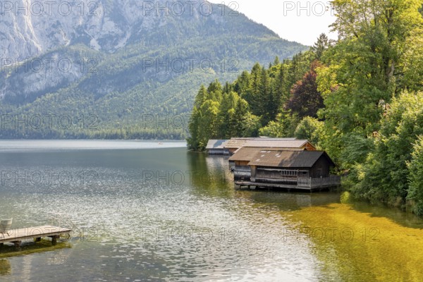 Lake Altaussee with boathouses on the shore, surrounded by wooded mountains, Altaussee, Styria, Austria