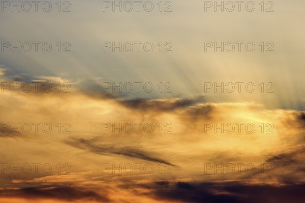 Sunset behind cloud cover, sunbeams, Oia, Thira, Santorini, Cyclades, Greece