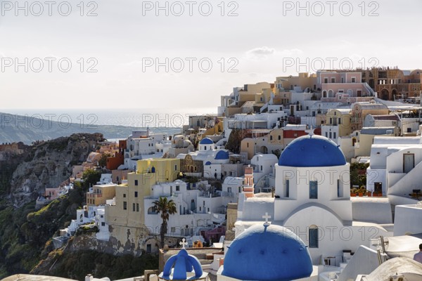 Typical architecture with white or colourfully whitewashed holiday homes and blue roofs, churches on the edge of the caldera, Oia, Thira, Santorini, Cyclades, Greece
