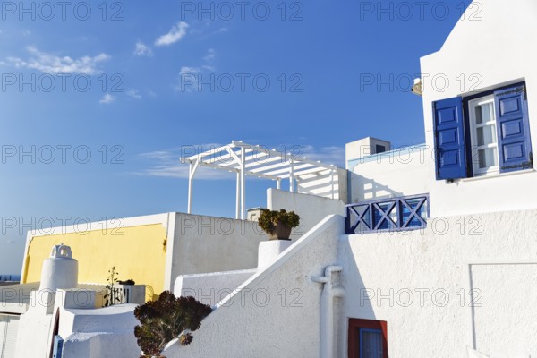 Architectural detail, typical white holiday homes, yellow wall, blue sky, Oia, Thira, Santorini, Cyclades, Greece