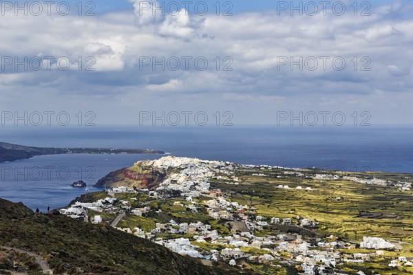 Coastline with view of the village of Oia, hiker on hiking trail from Fira to Oia, Thira, Santorini, Cyclades, Greece