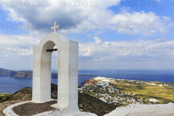 Love locks on the bell tower of an orthodox church, coastline, Oia on the horizon, hiking trail from Fira to Oia, Thira, Santorini, Cyclades, Greece