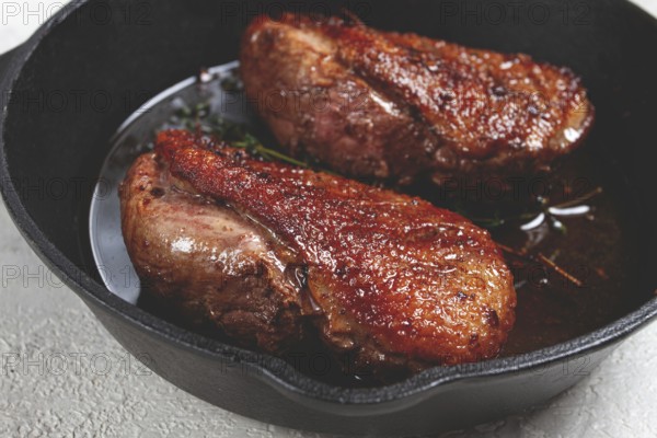 Roast duck breast, in a frying pan, with spices and herbs, close-up, no people